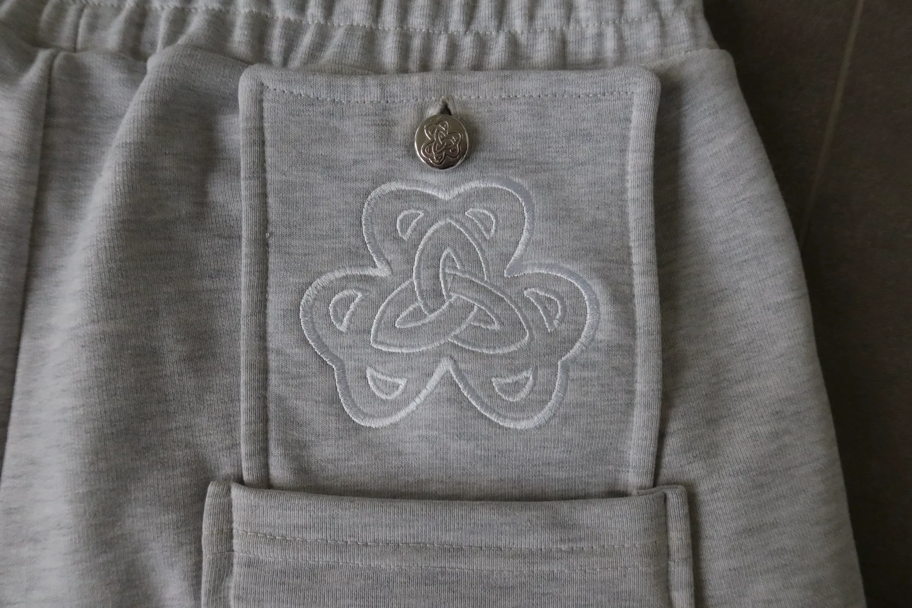 Embroidered clover and custom metal button on the CZX shorts